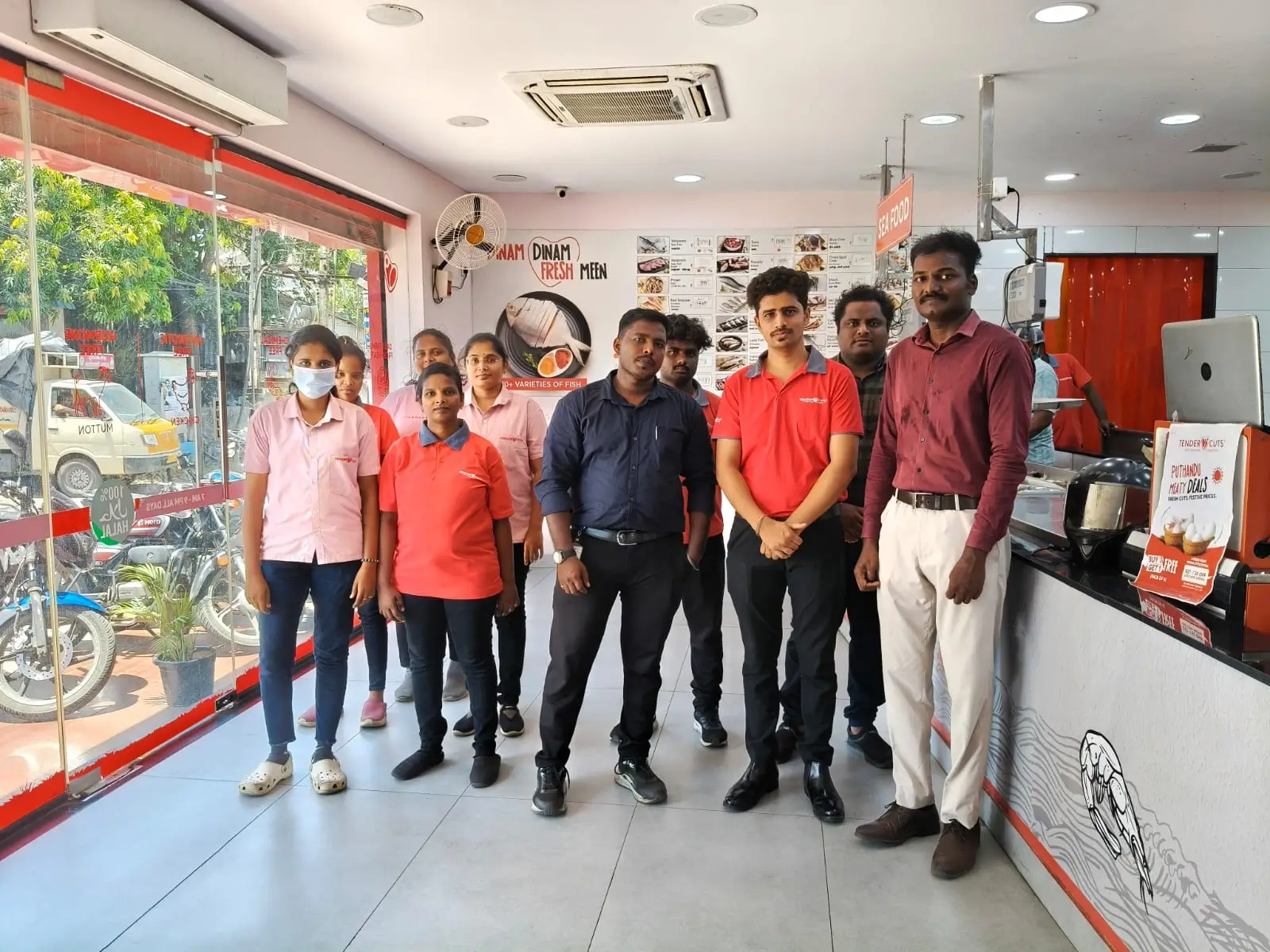 Food outlet staff standing together near the service counter of a street-facing store.